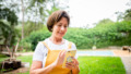 Vrouw met smartphone in de tuin