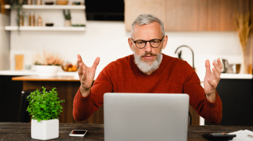 Man zit vertwijfeld achter laptop