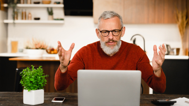 Man zit vertwijfeld achter laptop