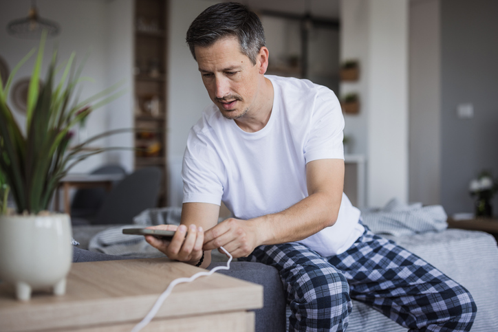 Man legt telefoon aan oplader