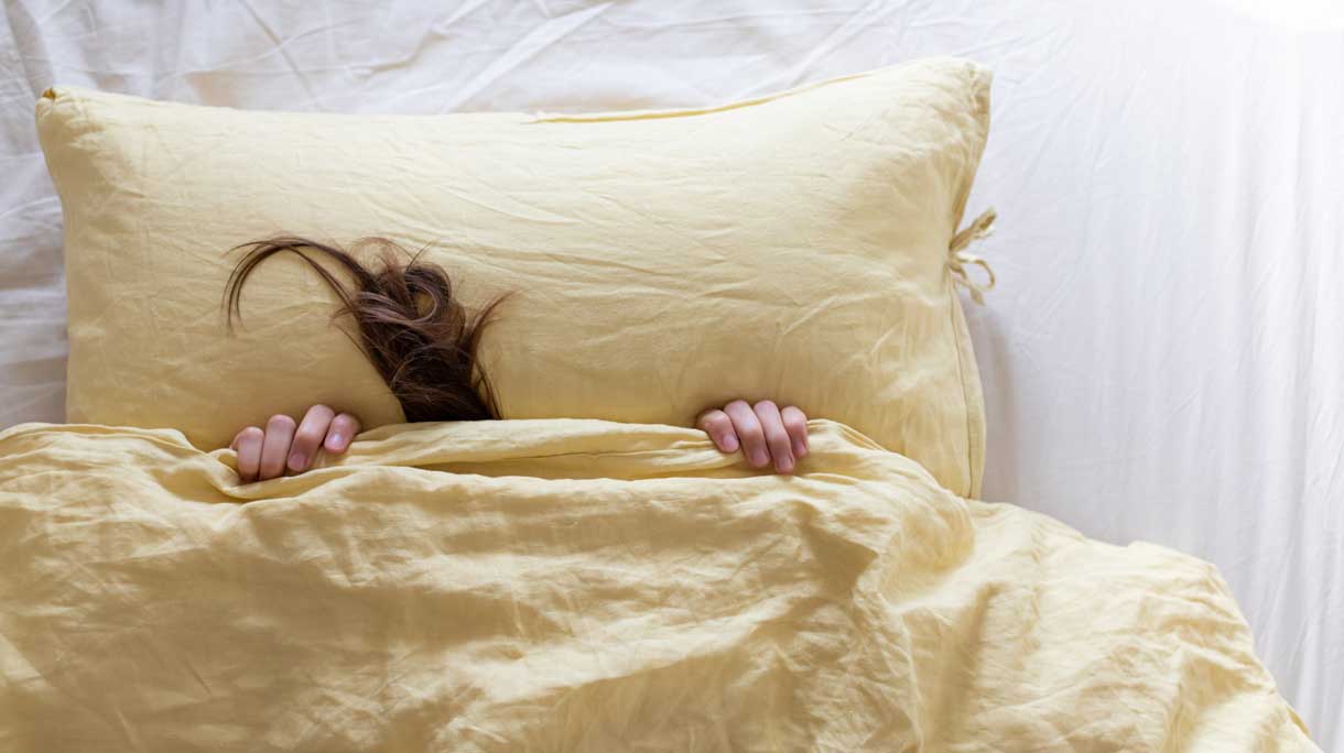 Pluk haar steekt onder dekbed uit