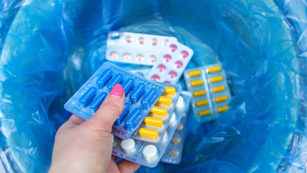 Vrouw gooit medicijnen in prullenbak