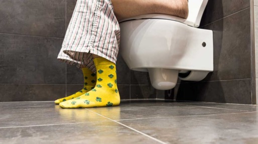 Man zittend op toilet