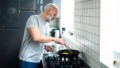 man staat te koken