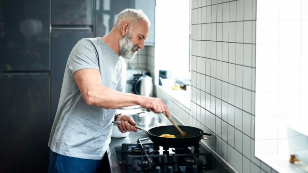 man staat te koken