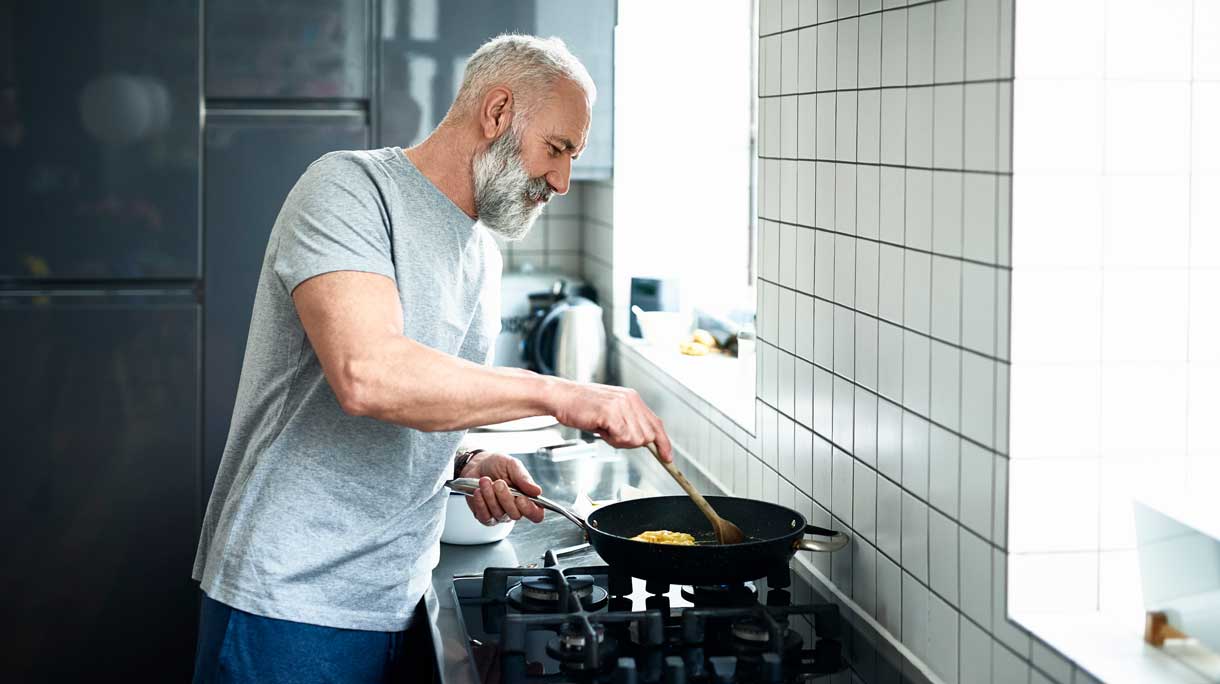 man staat te koken