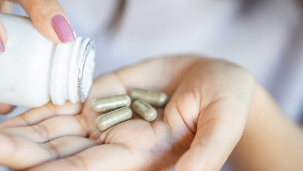 hand met kruidensupplementen