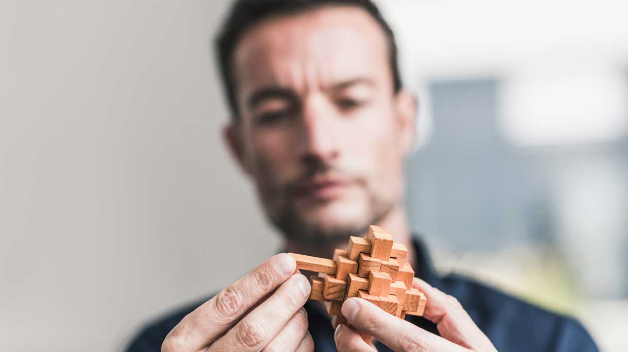 Man doet houten puzzeltje
