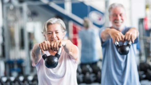 Twee fitte senioren trainen met gewichten