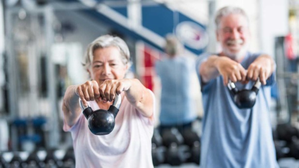 Twee fitte senioren trainen met gewichten