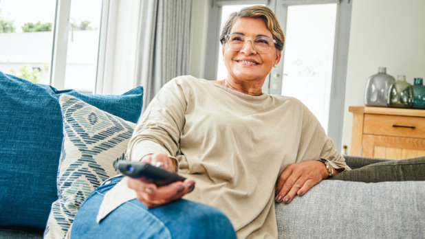 Vrouw kijkt TV op de bank