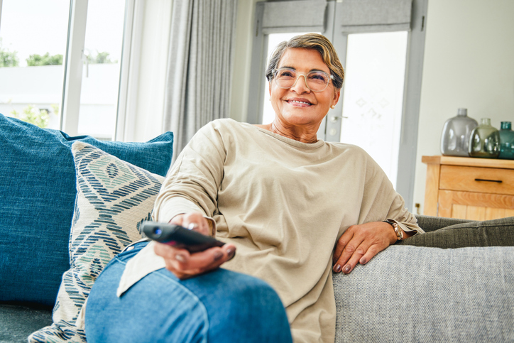 Vrouw kijkt TV op de bank