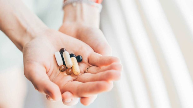 Handen met vitaminepillen