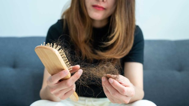 Een vrouw haalt haar uit haar borstel