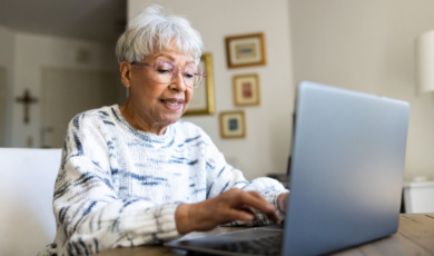 oudere vrouw typt op laptop