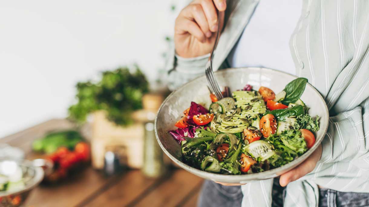 Vrouw eet gezonde salade met verse ingrediënten