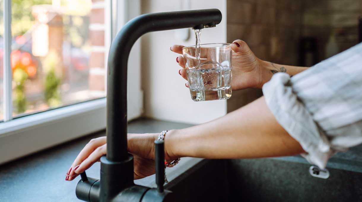 Vrouw tapt glas kraanwater