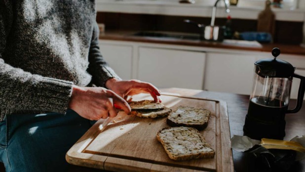 Man smeert boter op brood