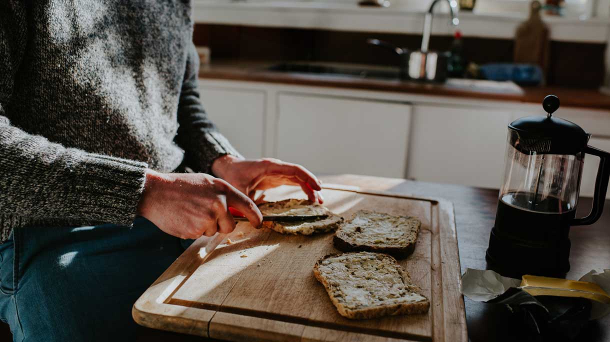 Man smeert boter op brood