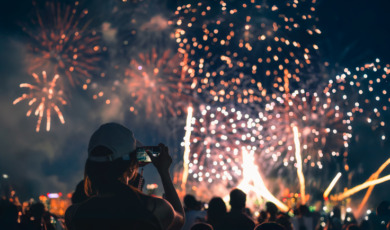 Vrouw kijkt met telefooncamera naar vuurwerkshow