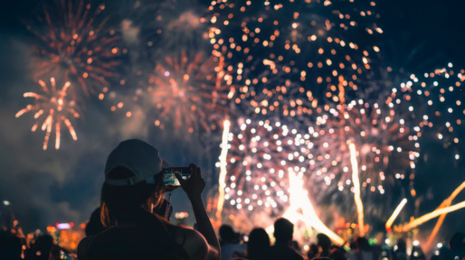Vrouw kijkt met telefooncamera naar vuurwerkshow