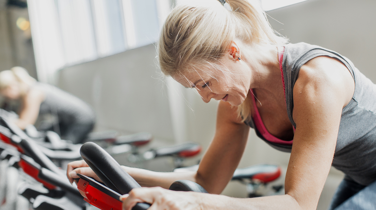 oudere vrouw doet aan spinning
