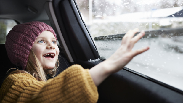 Meisje zit in besneeuwde auto