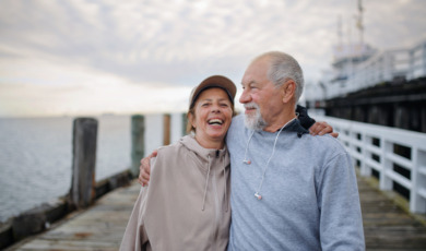 Man en vrouw lopen lachend over pier