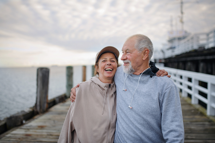 Man en vrouw lopen lachend over pier