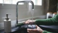 vrouw vult glas water aan kraan