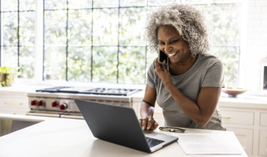 Vrouw met grijze afro zit achter laptop