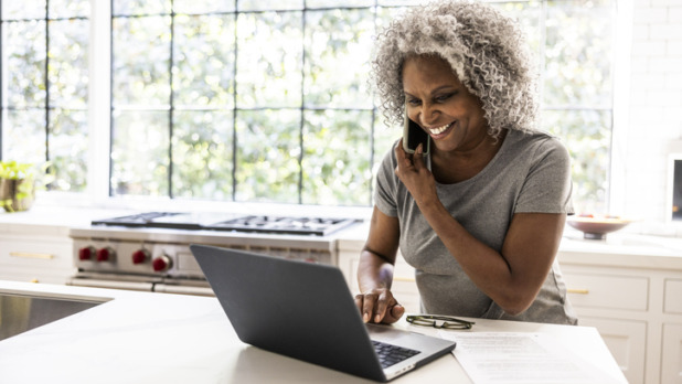 Vrouw met grijze afro zit achter laptop