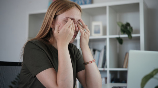 Vrouw met handen voor gezicht door computerproblemen