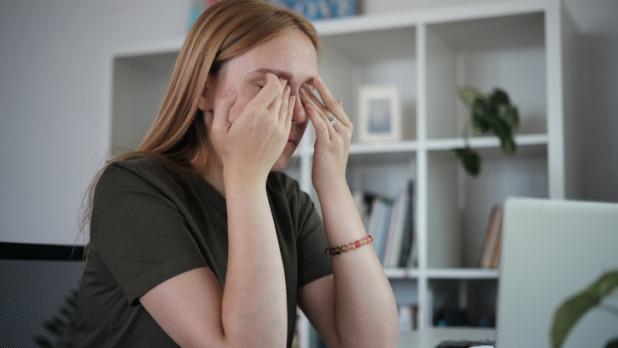 Vrouw met handen voor gezicht door computerproblemen