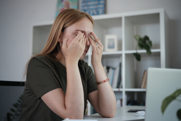 Vrouw met handen voor gezicht door computerproblemen