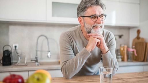 man drinkt water uit een glas in de keuken