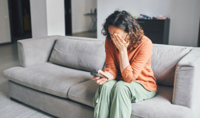 vrouw kijkt somber naar haar telefoon