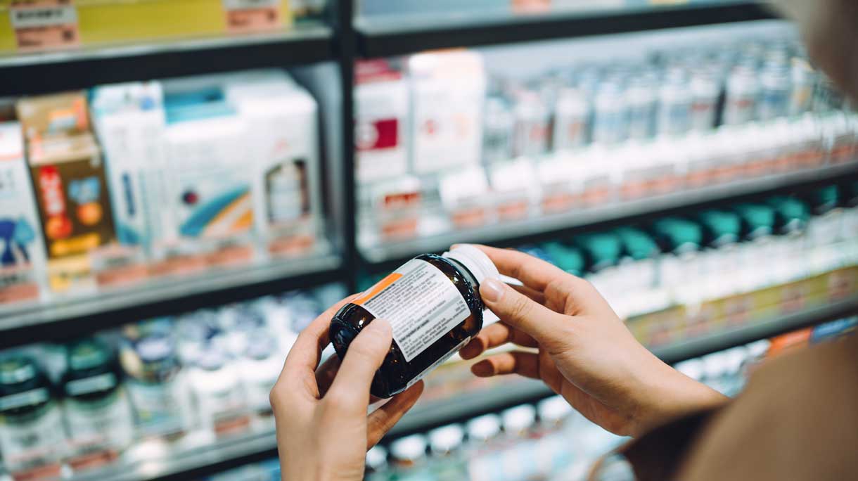 Vrouw bekijkt etiket voedingssupplement