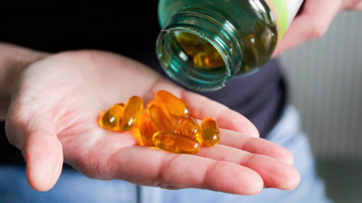 Hand met vitamine D pillen