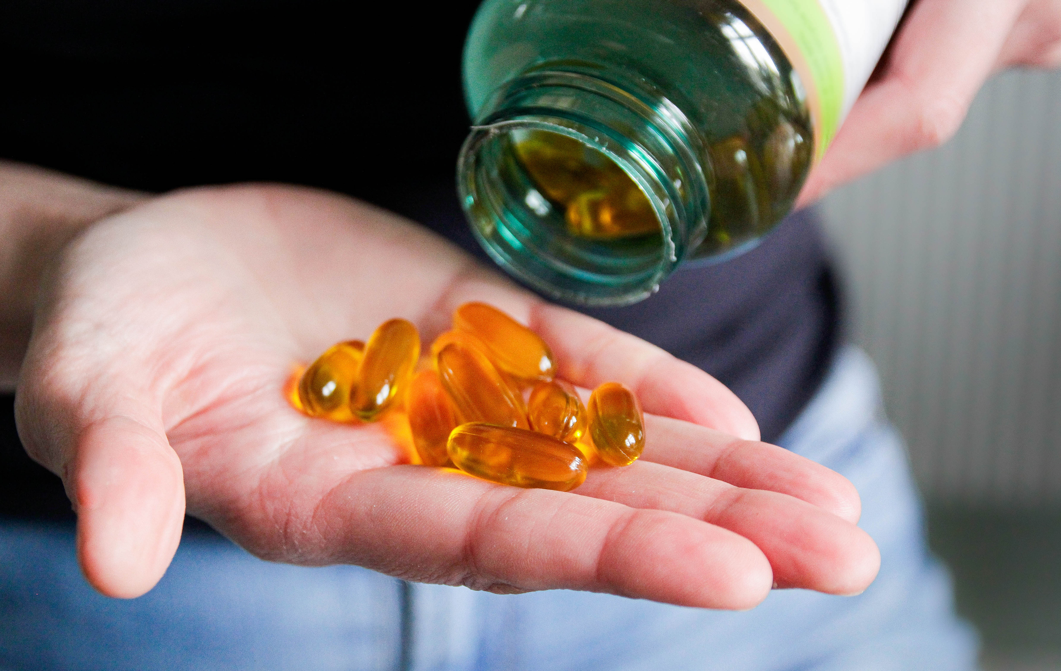 Hand met vitamine D pillen