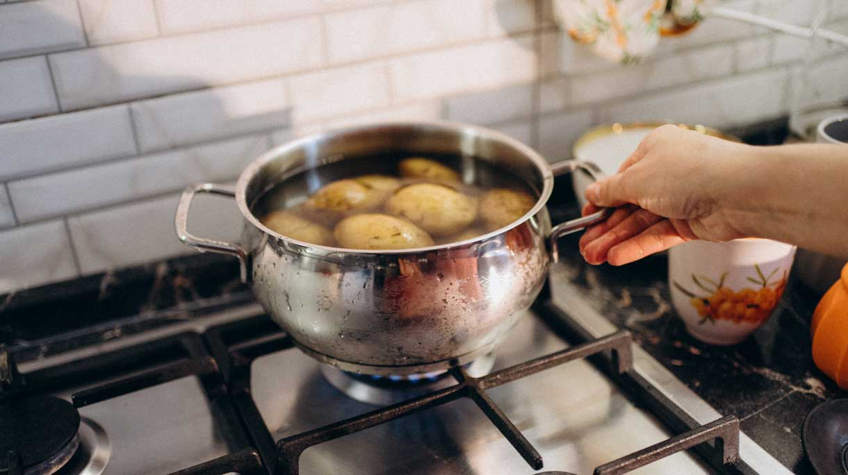 Pan met aardappelen op het gas