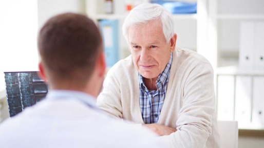 Man in gesprek met arts over zijn fysieke klachten