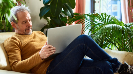 Man op de bank met laptop op schoot