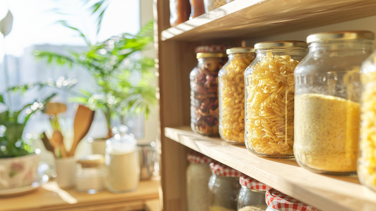 Voorraadpotten op een houten plank in een keuken