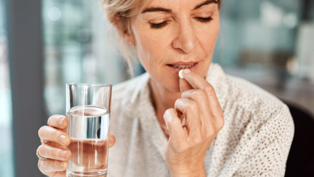 oudere vrouw slikt medicatie