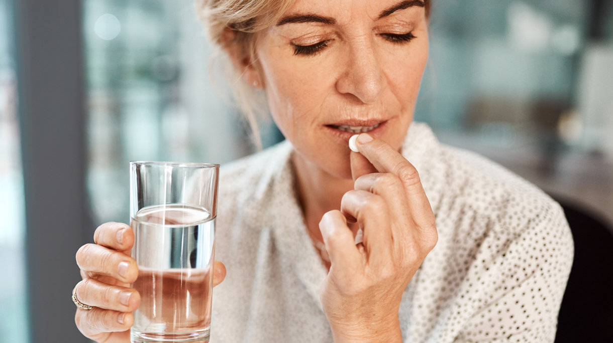 oudere vrouw slikt medicatie