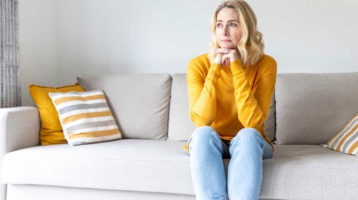 Vrouw zit op de bank en denkt na