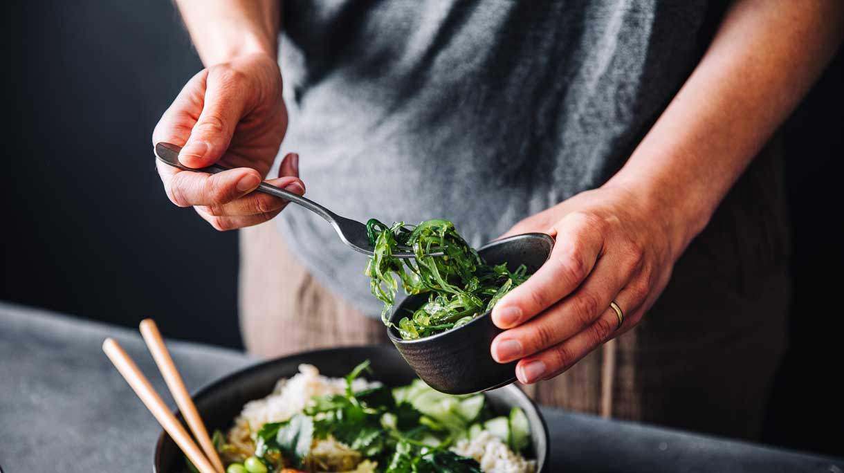 vrouw maakt salade met zeewier