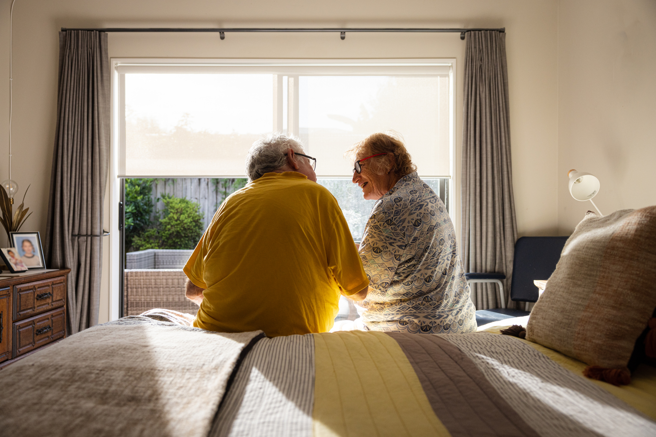 Man en vrouw zitten op rand bed