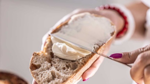 vrouw smeert margarine op brood